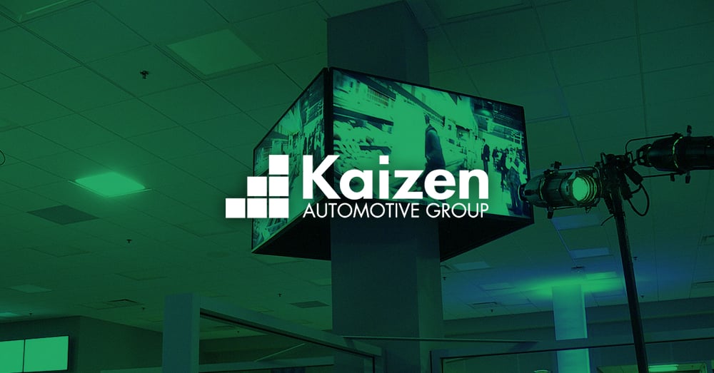 Mural de vídeo exibindo propaganda de automóveis em uma concessionária de propriedade do Grupo Kaizen Automotive com cobertura verde e logotipo